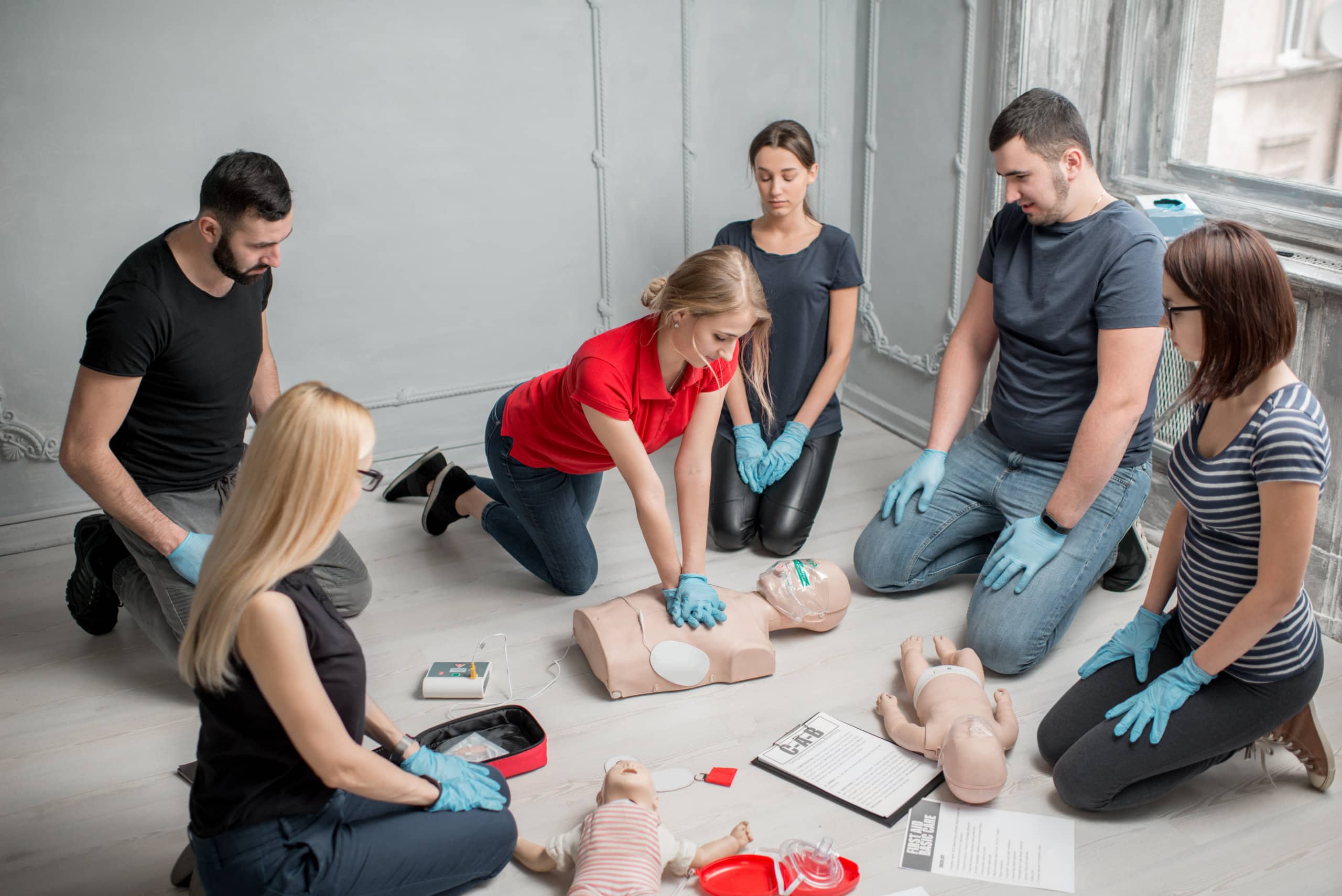 Instructors demonstrating CPR on mannequin at first aid training